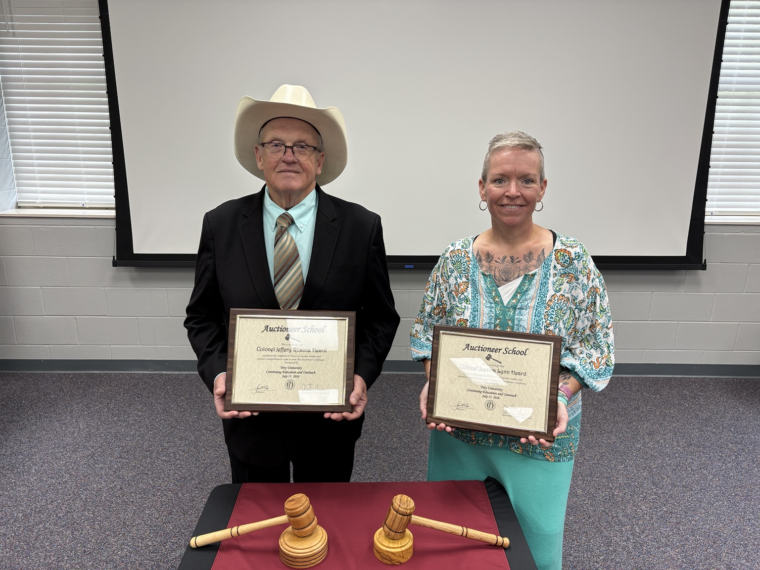 Jessica and Jeffery holding their Troy University Auctioneer School certificates